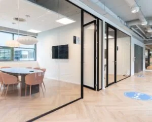 Moderne kantoorruimte met glazen vergaderruimtes in het Coengebouw aan de Kabelweg 37 in Amsterdam.