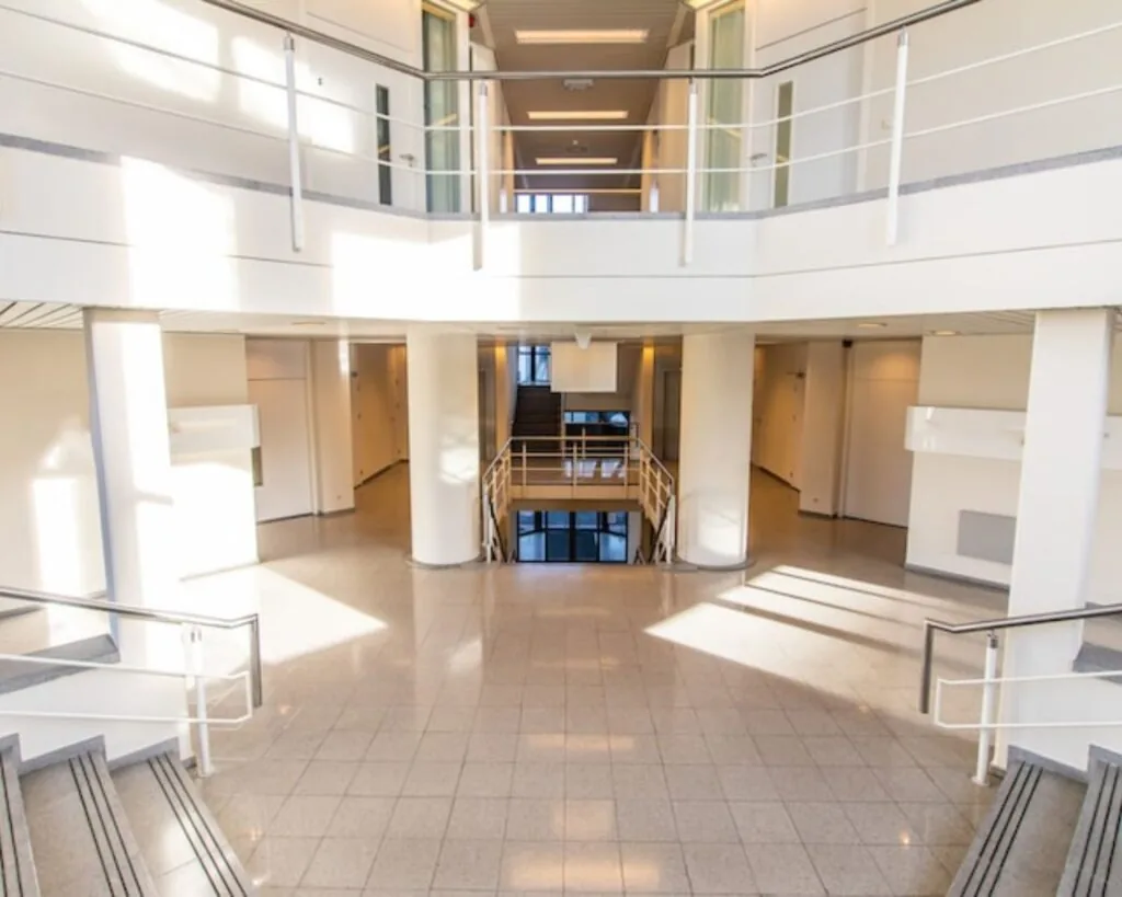 Moderne, ruime entreehal van een kantoorruimte aan de Gaetano Martinolaan 75-95 in Maastricht met veel natuurlijk licht en meerdere verdiepingen.