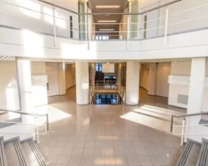 Moderne, ruime entreehal van een kantoorruimte aan de Gaetano Martinolaan 75-95 in Maastricht met veel natuurlijk licht en meerdere verdiepingen.