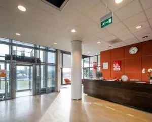 Moderne ontvangsthal van kantoorruimte aan Rietlandpark 302 in Amsterdam met balie, zitgedeelte en glazen entree.