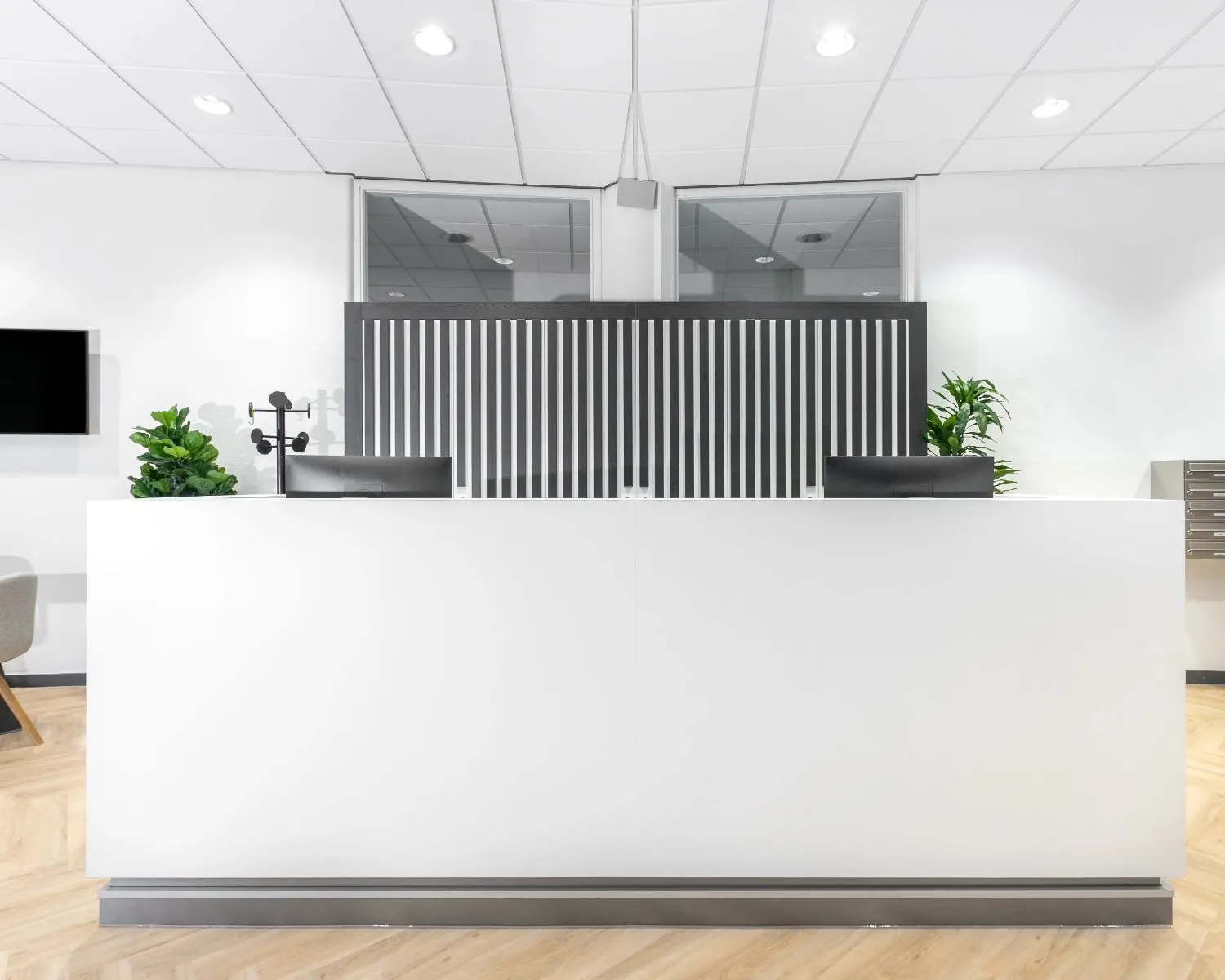 Moderne receptiebalie met strakke witte afwerking in kantoorruimte aan het Capitool 10 in Enschede.