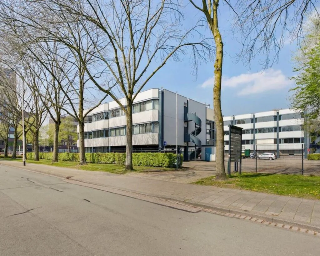 Moderne kantoorruimte aan de Hooilaan 1 in Breda met parkeergelegenheid en omringd door bomen.