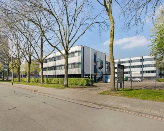 Moderne kantoorruimte aan de Hooilaan 1 in Breda met parkeergelegenheid en omringd door bomen.
