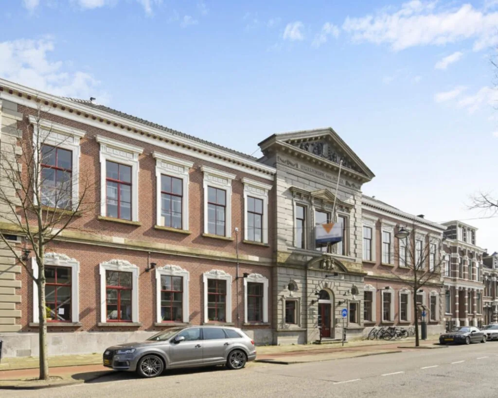 Vooraanzicht van een statig kantoorpand aan de Wilhelminastraat 43A in Haarlem met geparkeerde auto's ervoor.