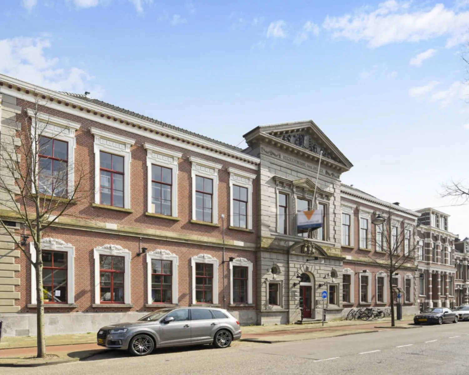 Vooraanzicht van een statig kantoorpand aan de Wilhelminastraat 43A in Haarlem met geparkeerde auto's ervoor.