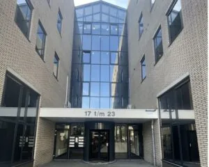 Entree van het kantoorgebouw aan de Zekeringstraat 17 t/m 23 in Amsterdam met glazen gevel en draaideur.