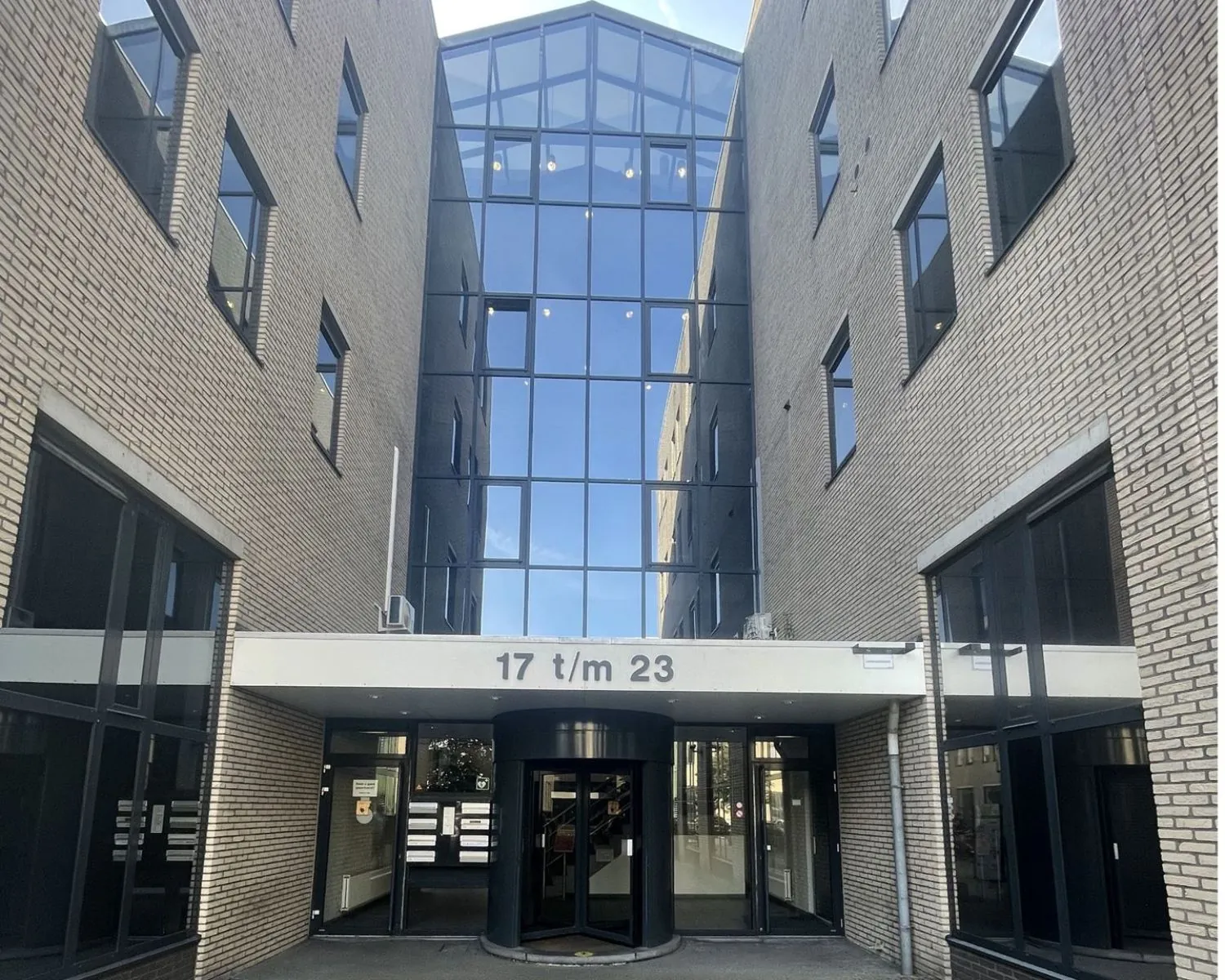 Entree van het kantoorgebouw aan de Zekeringstraat 17 t/m 23 in Amsterdam met glazen gevel en draaideur.