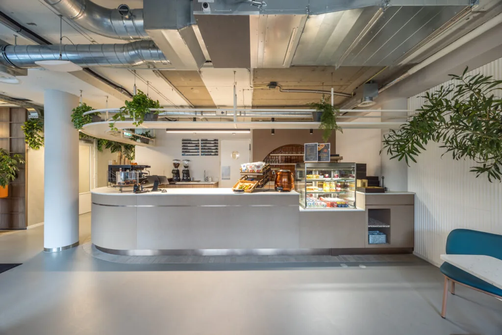 Moderne koffiebalie met zitgedeelte in een kantoorruimte in Den Haag.