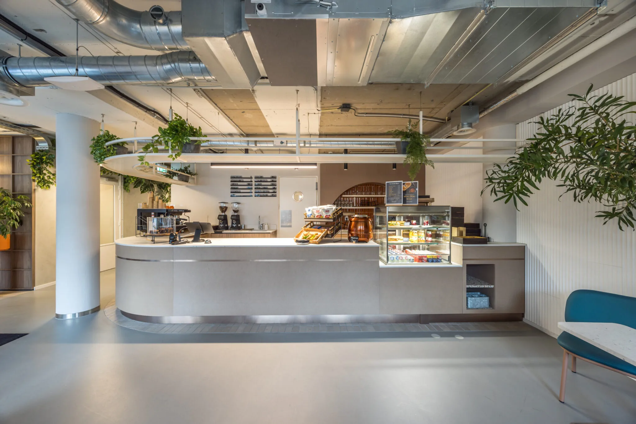 Moderne koffiebalie met zitgedeelte in een kantoorruimte in Den Haag.