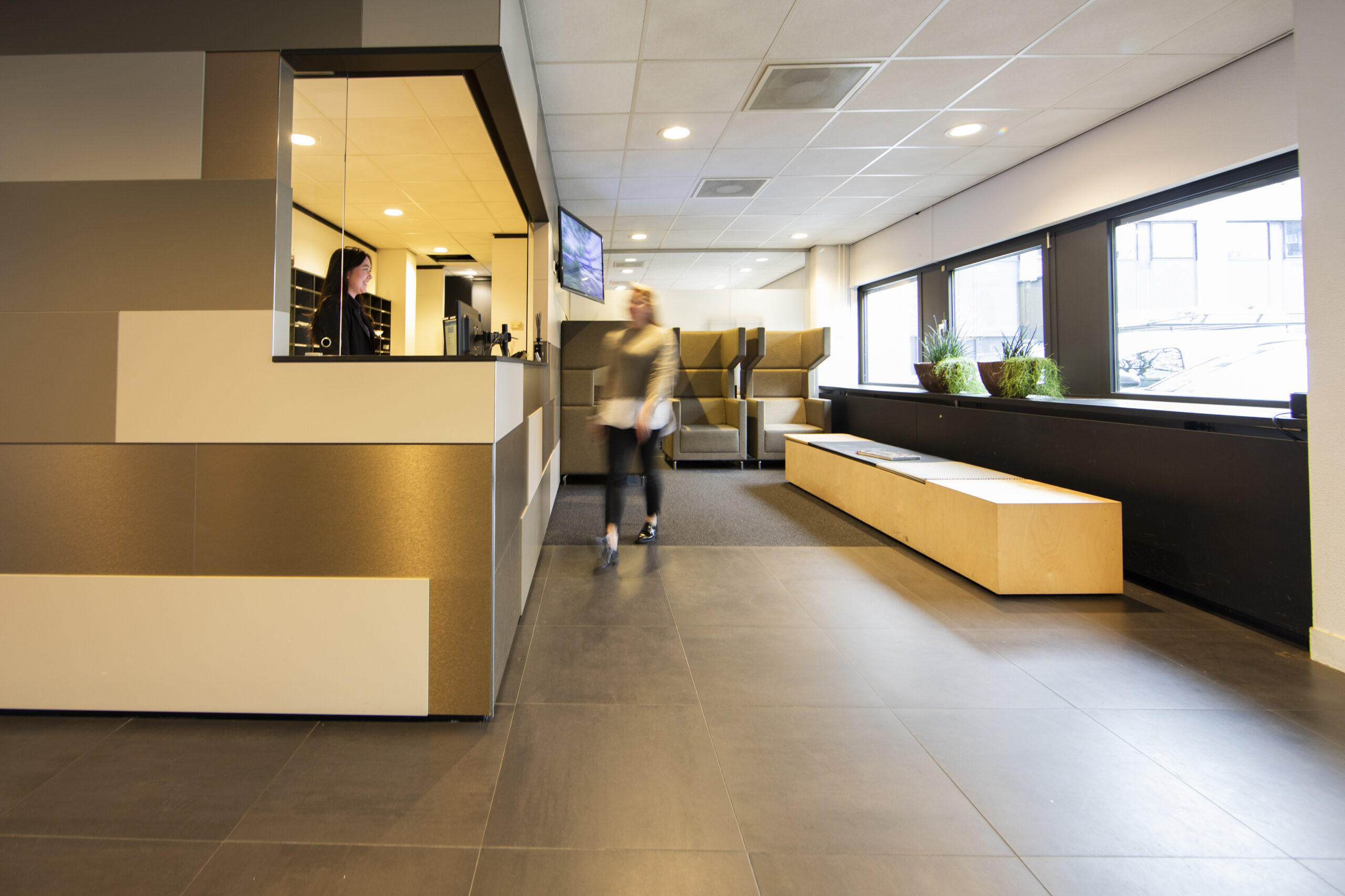 Een moderne entree met balie, zithoek en grote ramen aan de Winthontlaan 15.