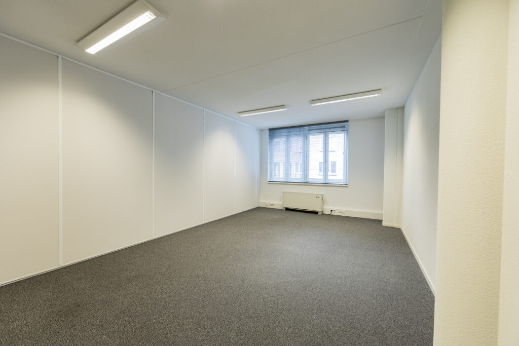 Lege kantoorruimte op de 20e etage van Vleuterweide, met witte muren, grijze vloerbedekking en grote ramen.