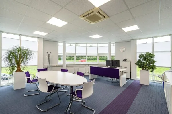 Modern ingericht kantoor op Rhijnspoor met grote ramen, witte meubels en paarse accenten.
