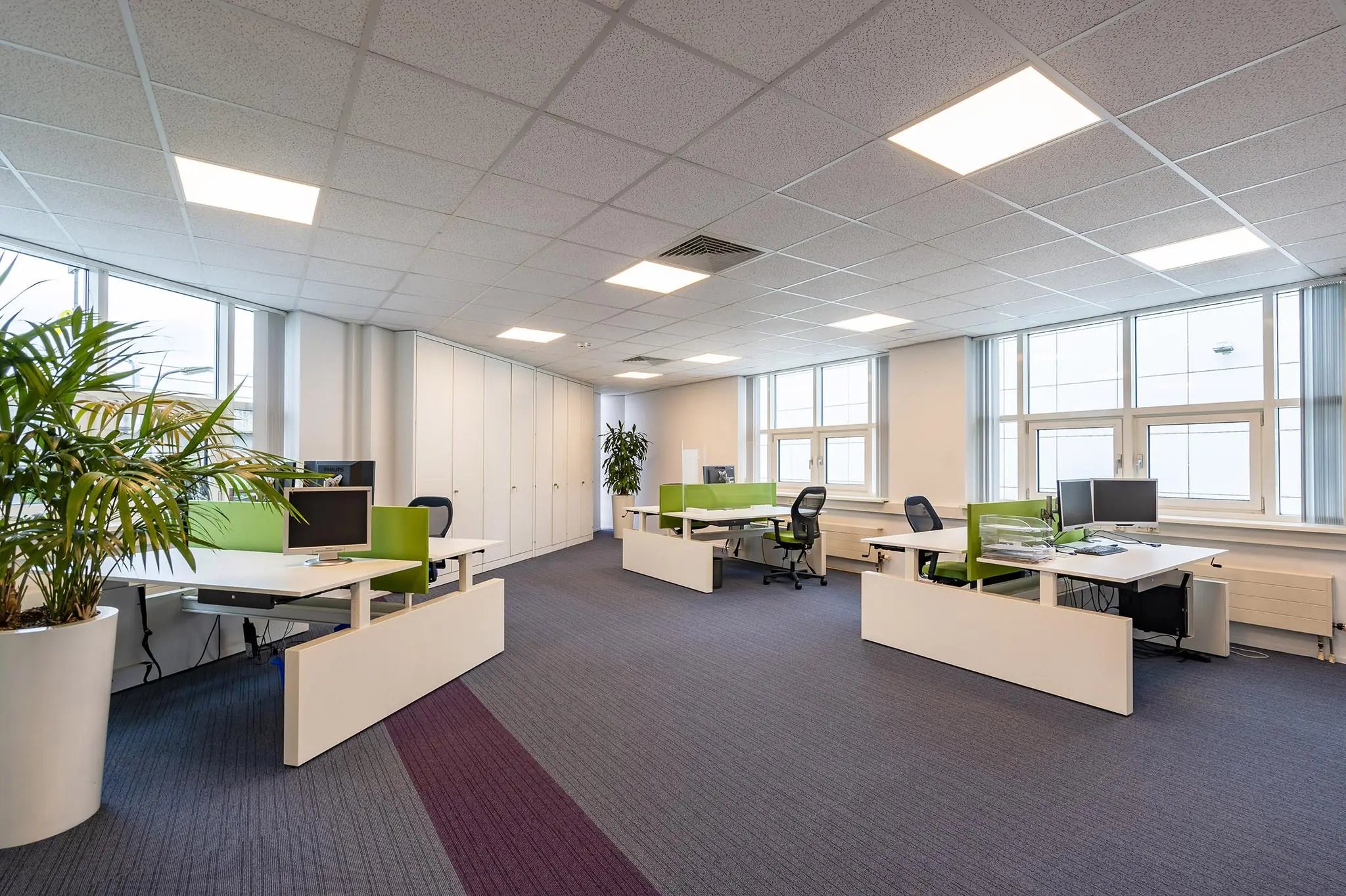 Modern en licht kantoorinterieur aan het Rhijnspoor met werkplekken, bureaustoelen en groene accenten.