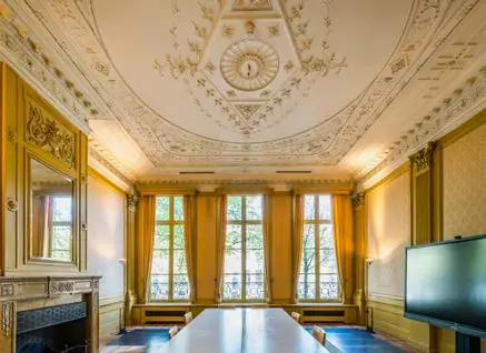 Vergaderkamer aan de Herengracht met hoge ramen, sierplafond en klassieke inrichting.