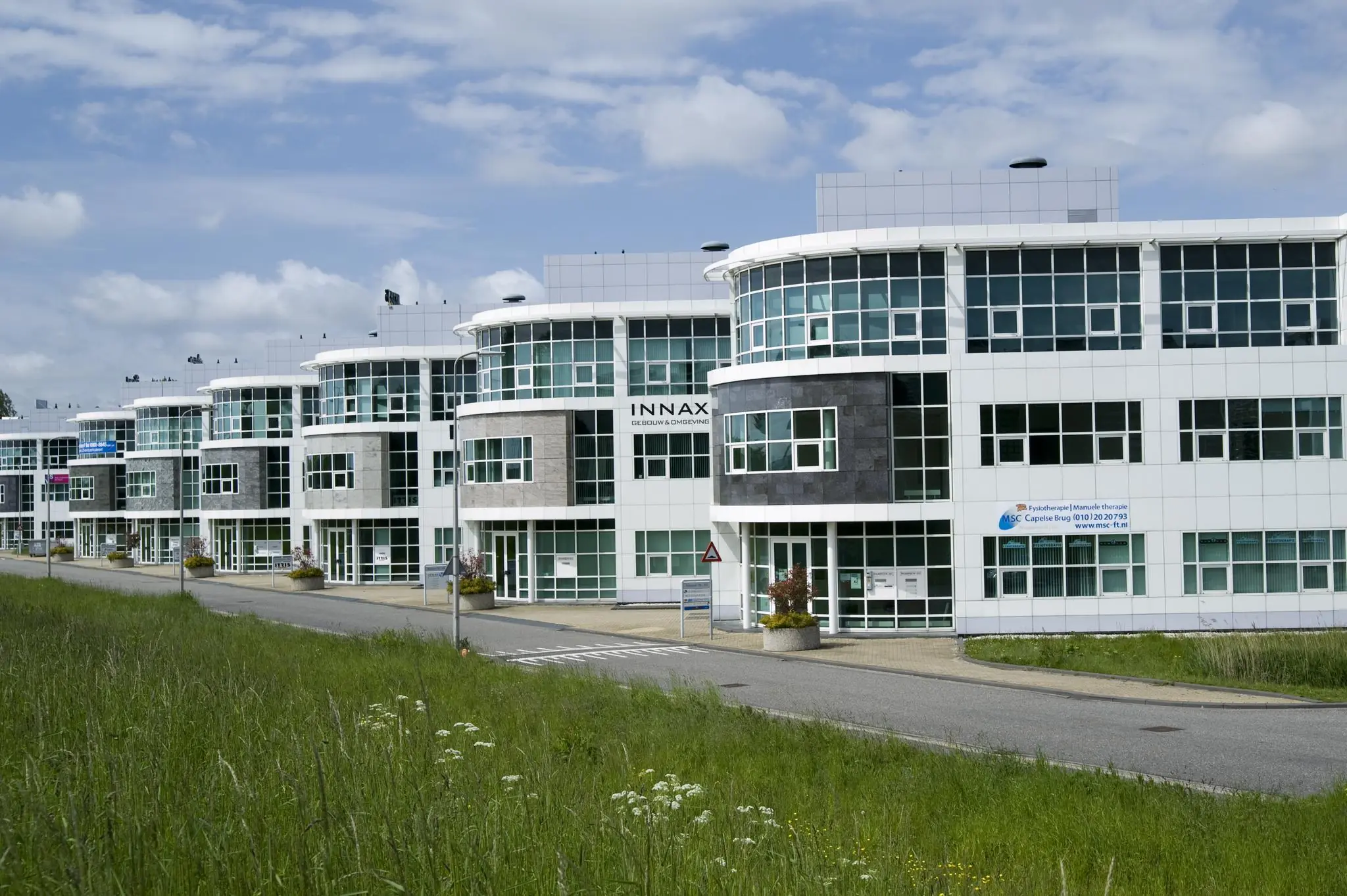 Moderne kantoorpanden aan de Rhijnspoor in Capelle aan den IJssel onder een deels bewolkte hemel.