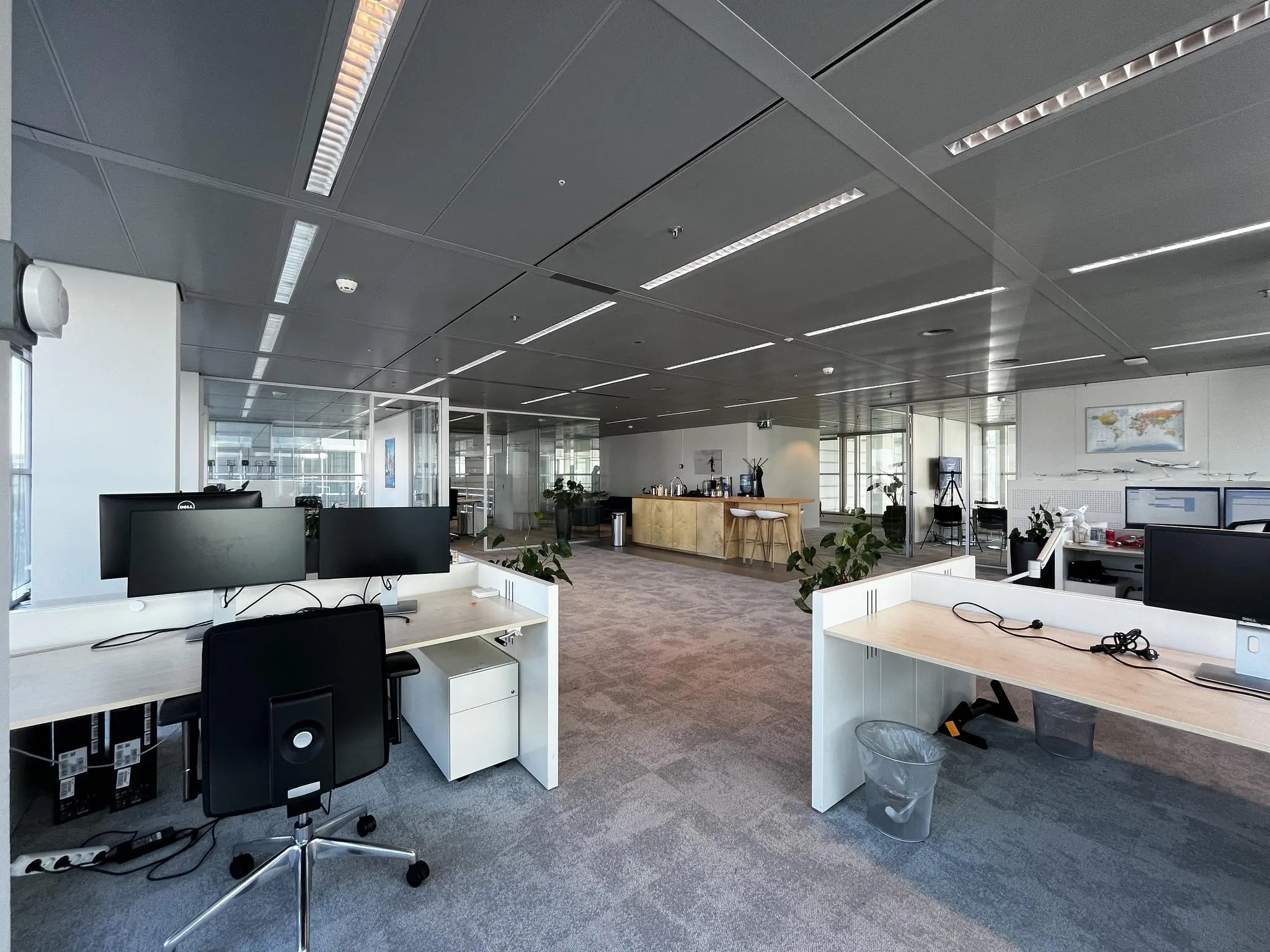 Moderne en ruime kantoorruimte aan de Reactorweg met werkplekken, planten en een open pantry.