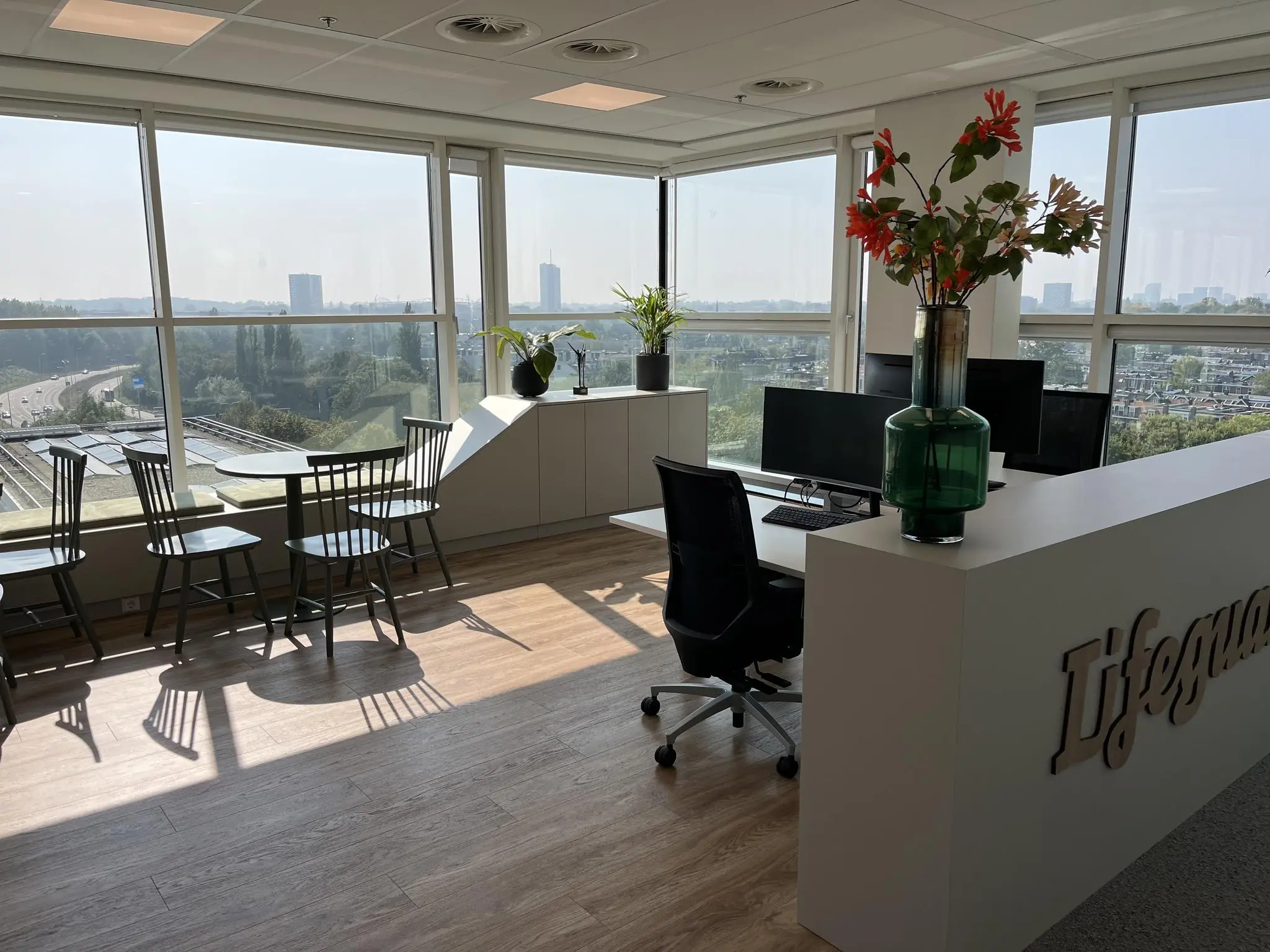 Modern kantoorinterieur aan de Newtonlaan met werkplekken, zitgedeelte en uitzicht op de stad.