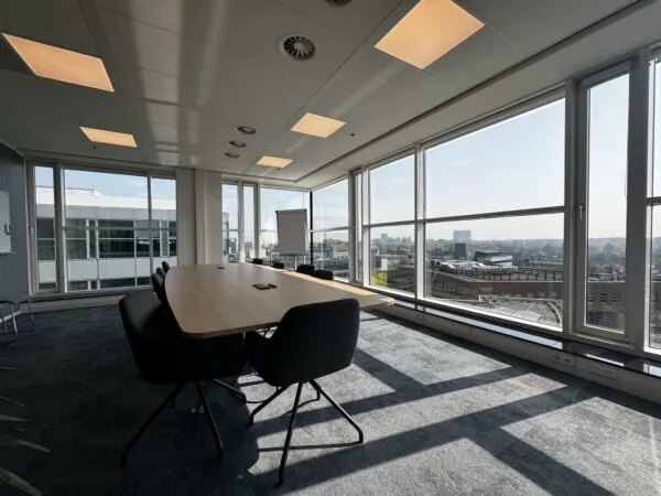 Vergaderruimte met grote ramen en uitzicht over de stad aan de Newtonlaan.