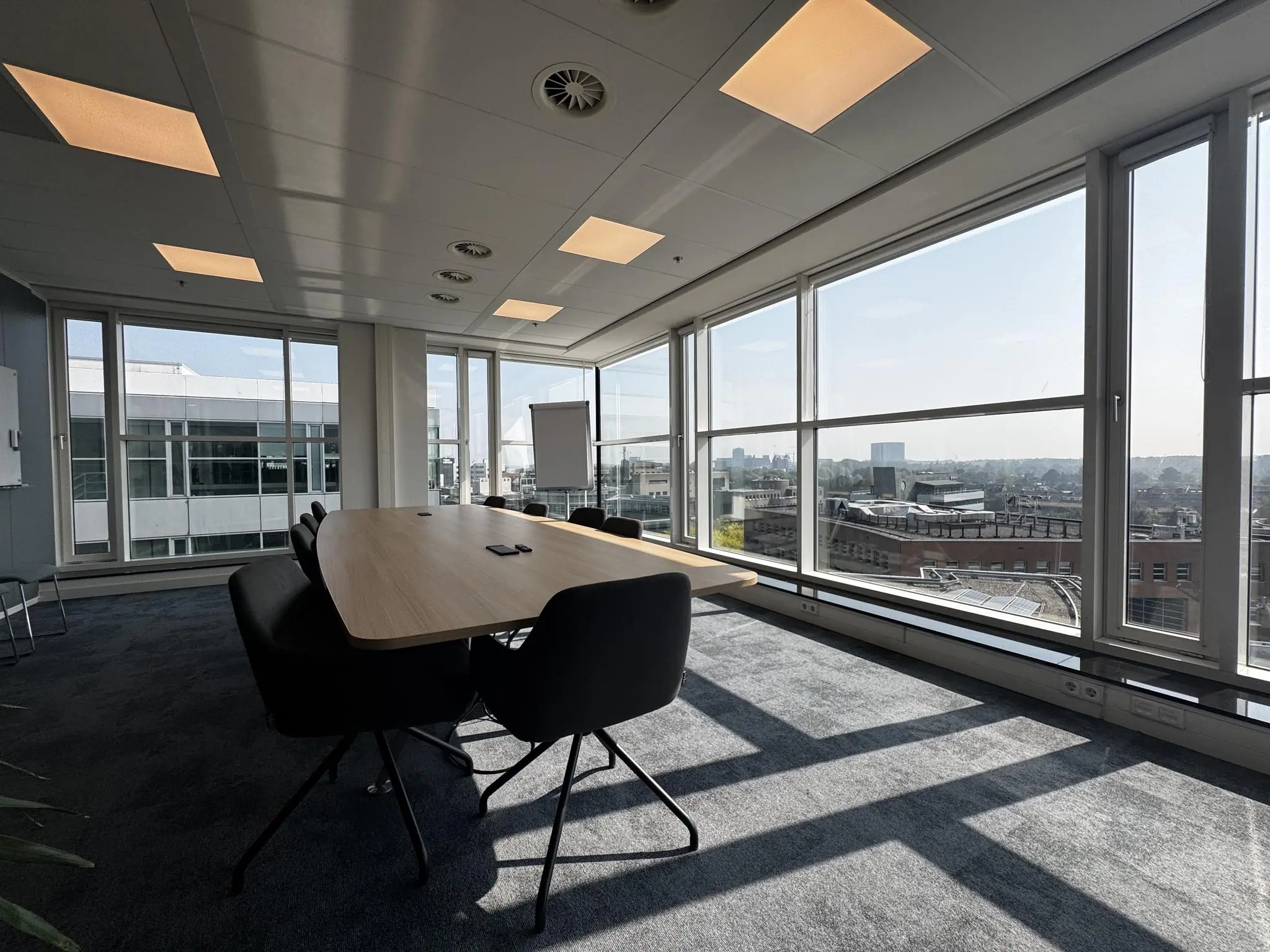 Vergaderruimte met grote ramen en uitzicht over de stad aan de Newtonlaan.