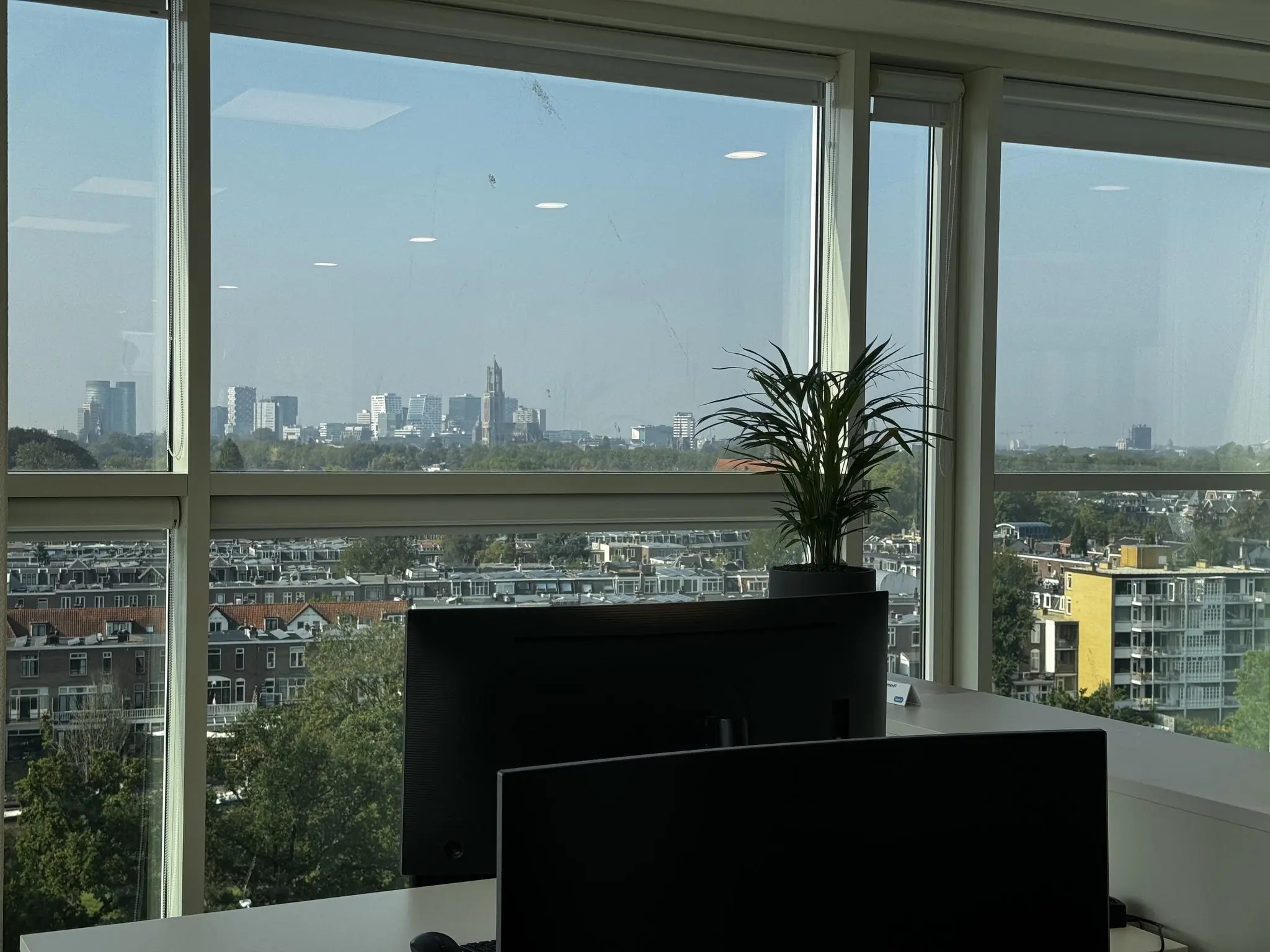Uitzicht vanuit een kantoor aan de Newtonlaan op de skyline van Utrecht met de Domtoren in de verte.