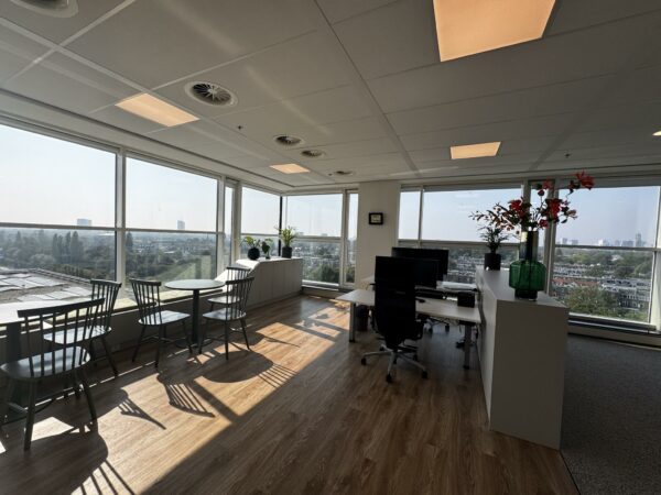 Modern hoekkantoor aan de Newtonlaan met grote ramen, een bureau, zitgedeelte en uitzicht over de stad.
