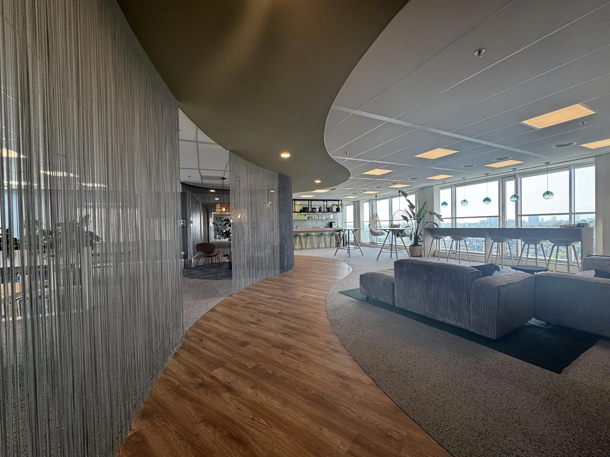Moderne kantoorruimte aan de Newtonlaan met zithoeken, een bar en panoramisch uitzicht over de stad.