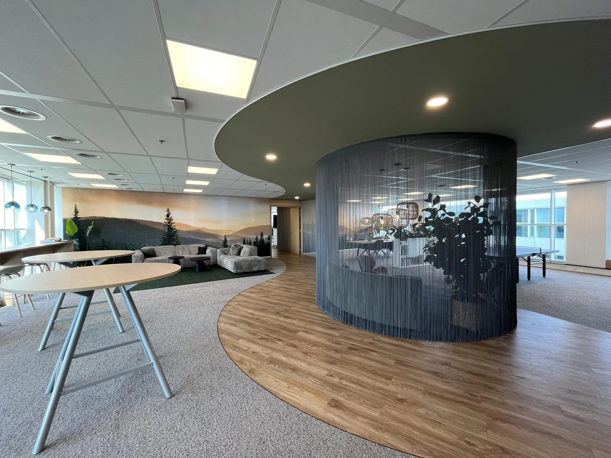 Moderne kantoorruimte aan de Newtonlaan met loungehoek, ronde vergaderruimte en natuurwanddecoratie.