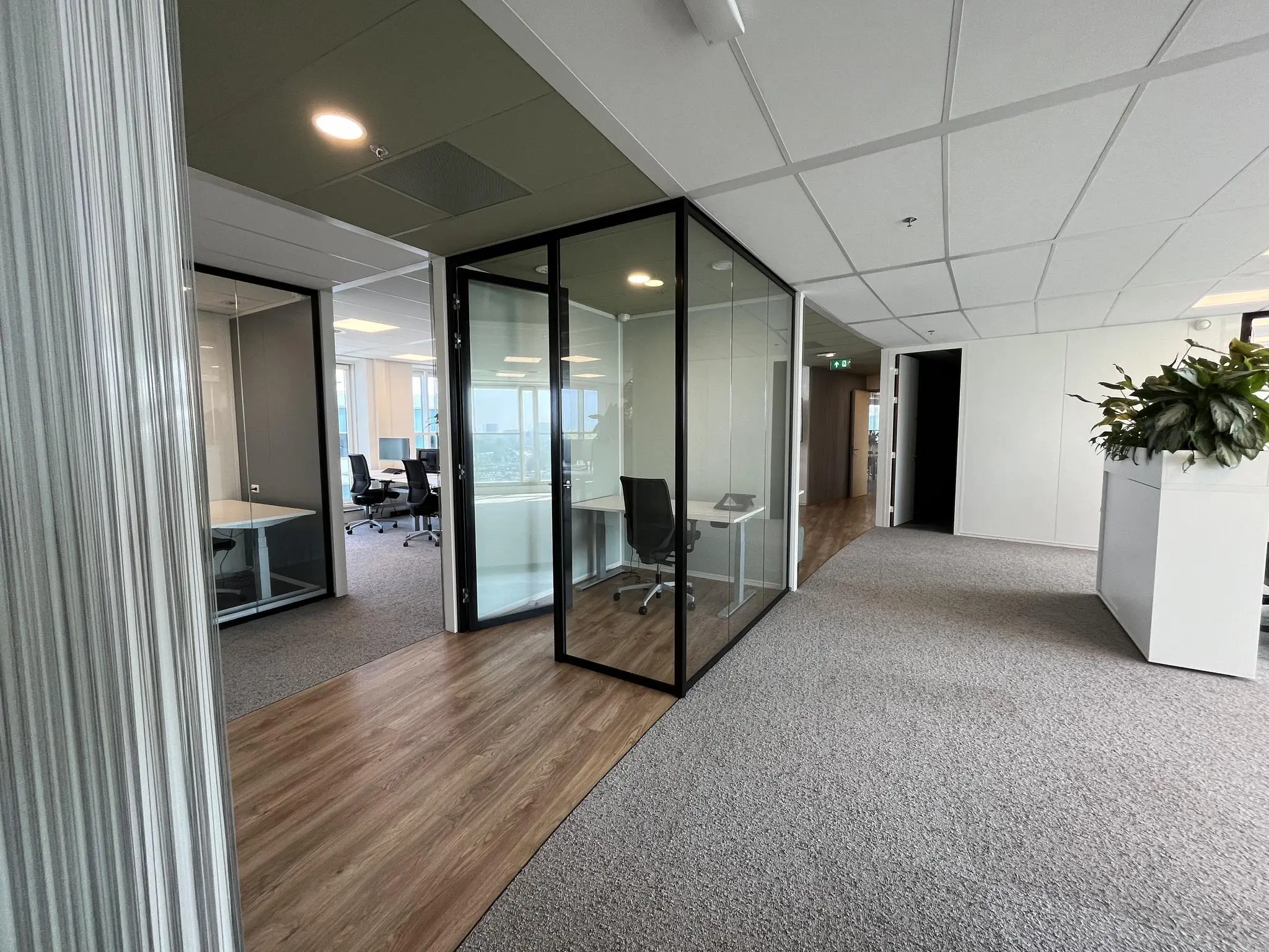 Moderne kantoorruimte aan de Newtonlaan met glazen vergaderruimtes en een lichte, open inrichting.