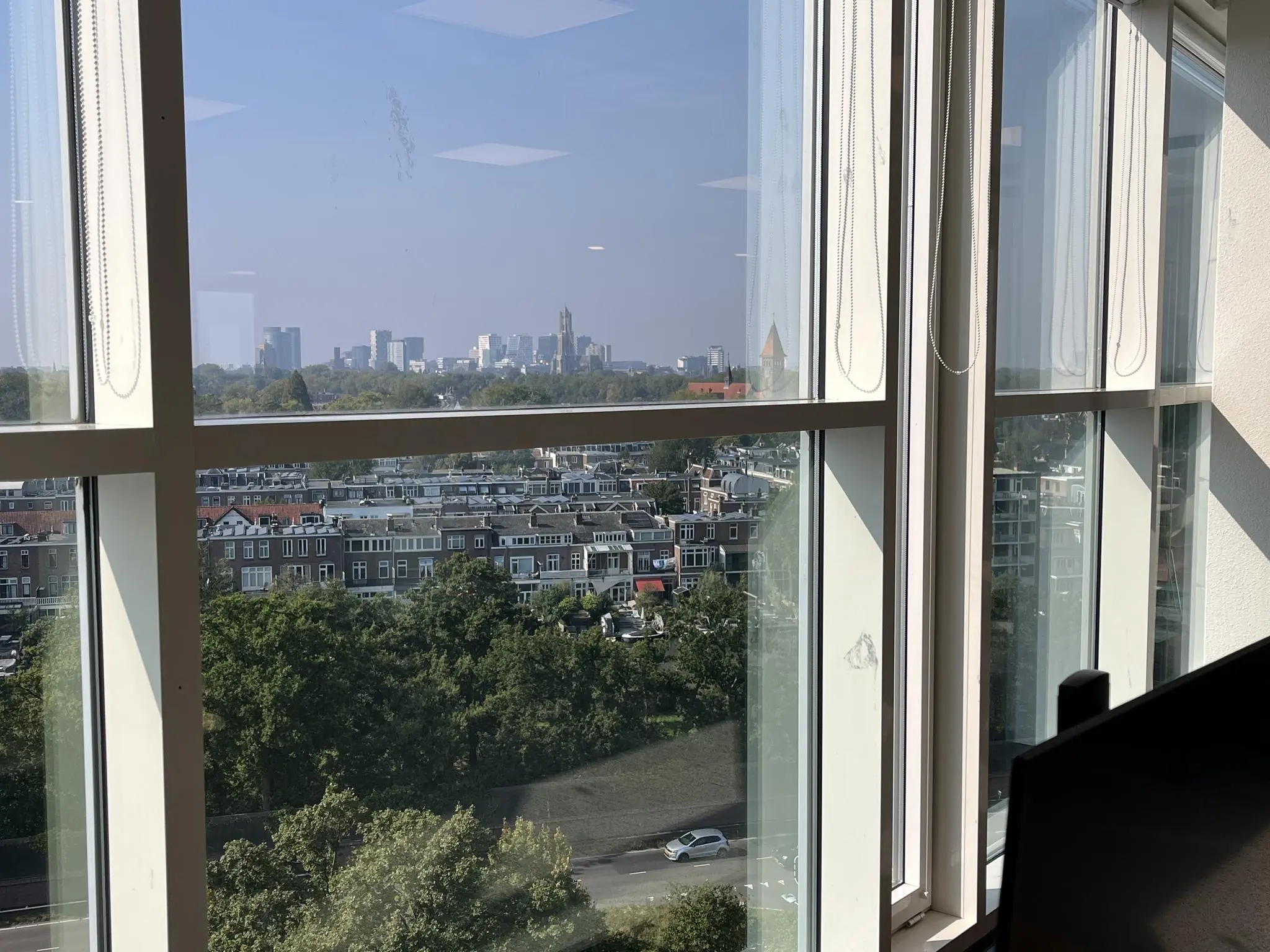 Uitzicht vanaf Newtonlaan op de skyline van Utrecht met woonhuizen en groen op de voorgrond.