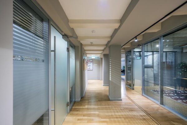 Modern kantoorinterieur met glazen vergaderruimtes en een houten vloer aan de Herengracht.
