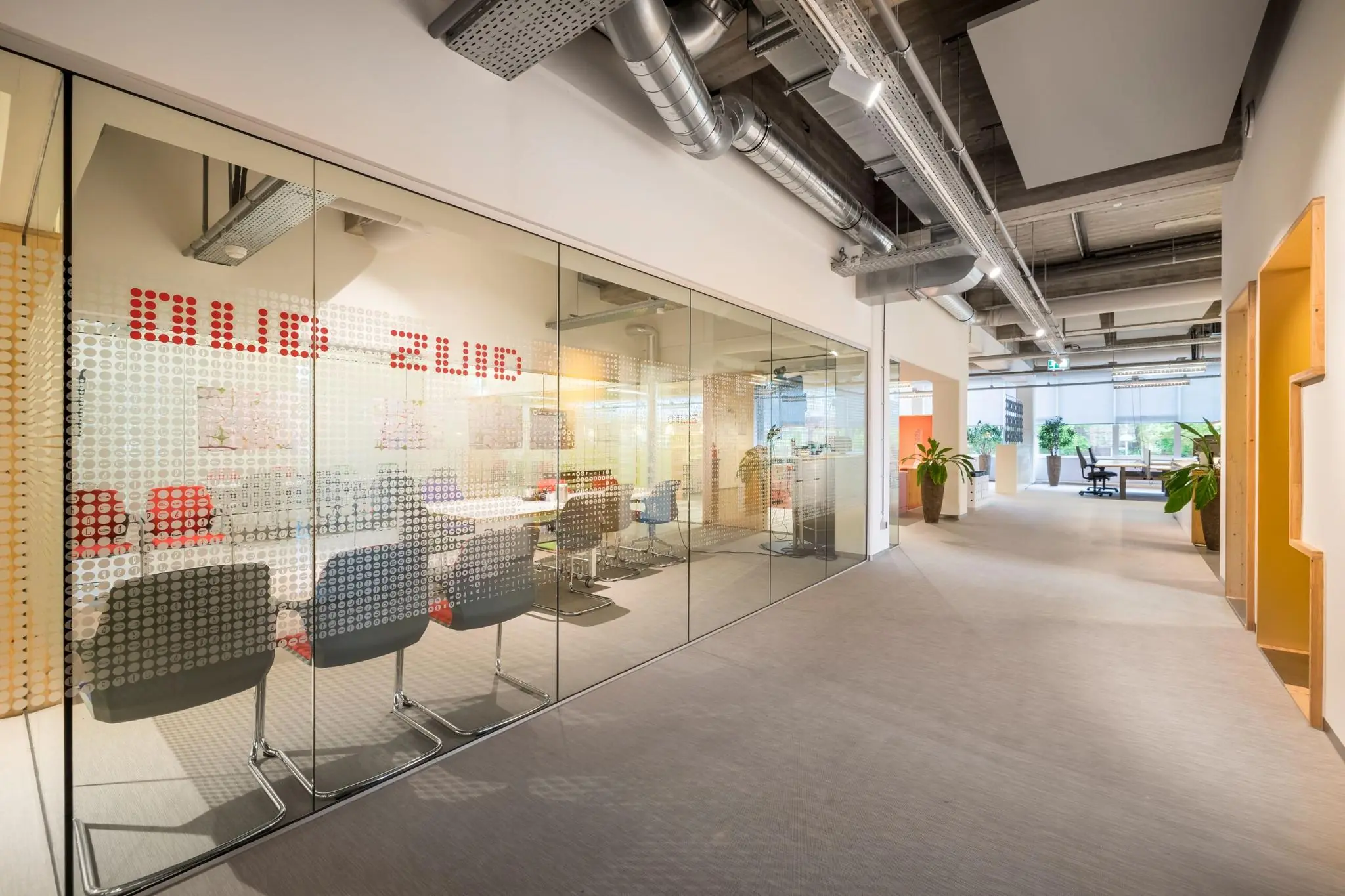 Moderne kantoorruimte aan de Helmholtzstraat met glazen vergaderruimte genaamd 'Oud Zuid' en open werkplekken.