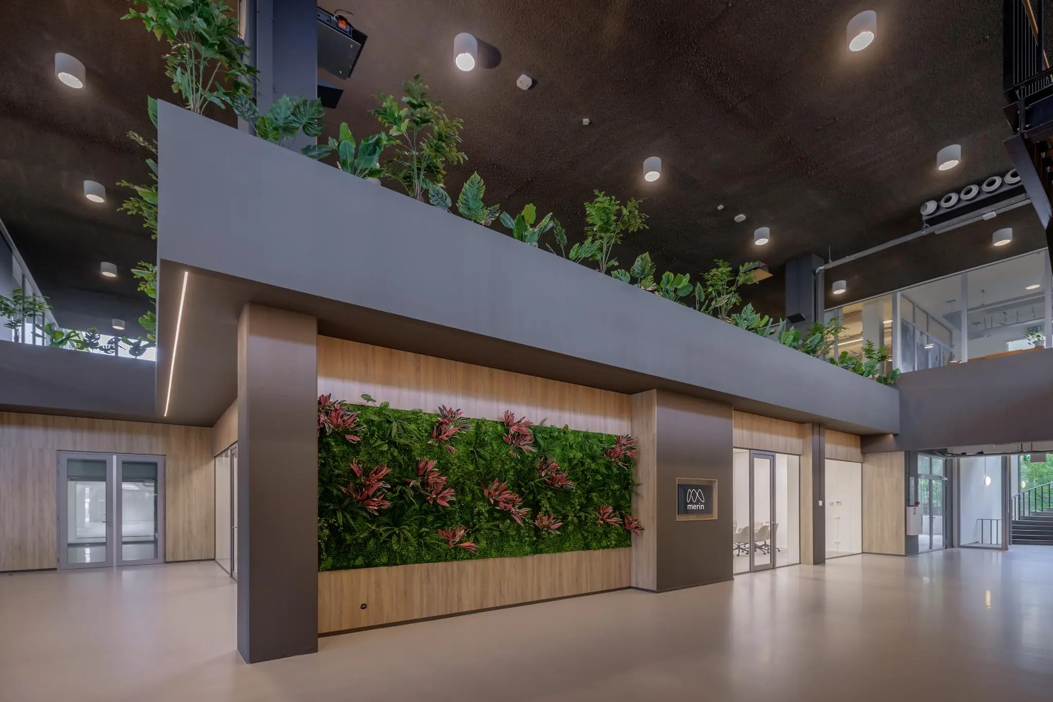 Moderne kantoorentree aan de Helmholtzstraat met een groene plantenwand en strak interieurdesign.