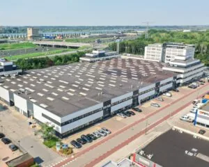 Luchtfoto van een groot industrieel bedrijfsverzamelgebouw aan de A10 in Amsterdam, genaamd Nieuw Overamstel.