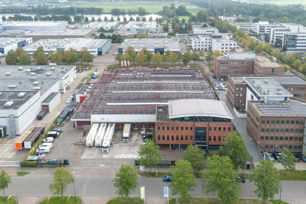 Luchtfoto van bedrijventerrein Veldzigt met kantoren, loodsen en vrachtwagens.