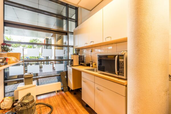 Kleine pantry met magnetron, koffiezetapparaat en opbergruimte in een bedrijfsruimte aan Veldzigt.