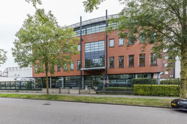 Modern kantoorgebouw aan de Veldzigt 3 met een bakstenen gevel en grote glazen raampartijen.