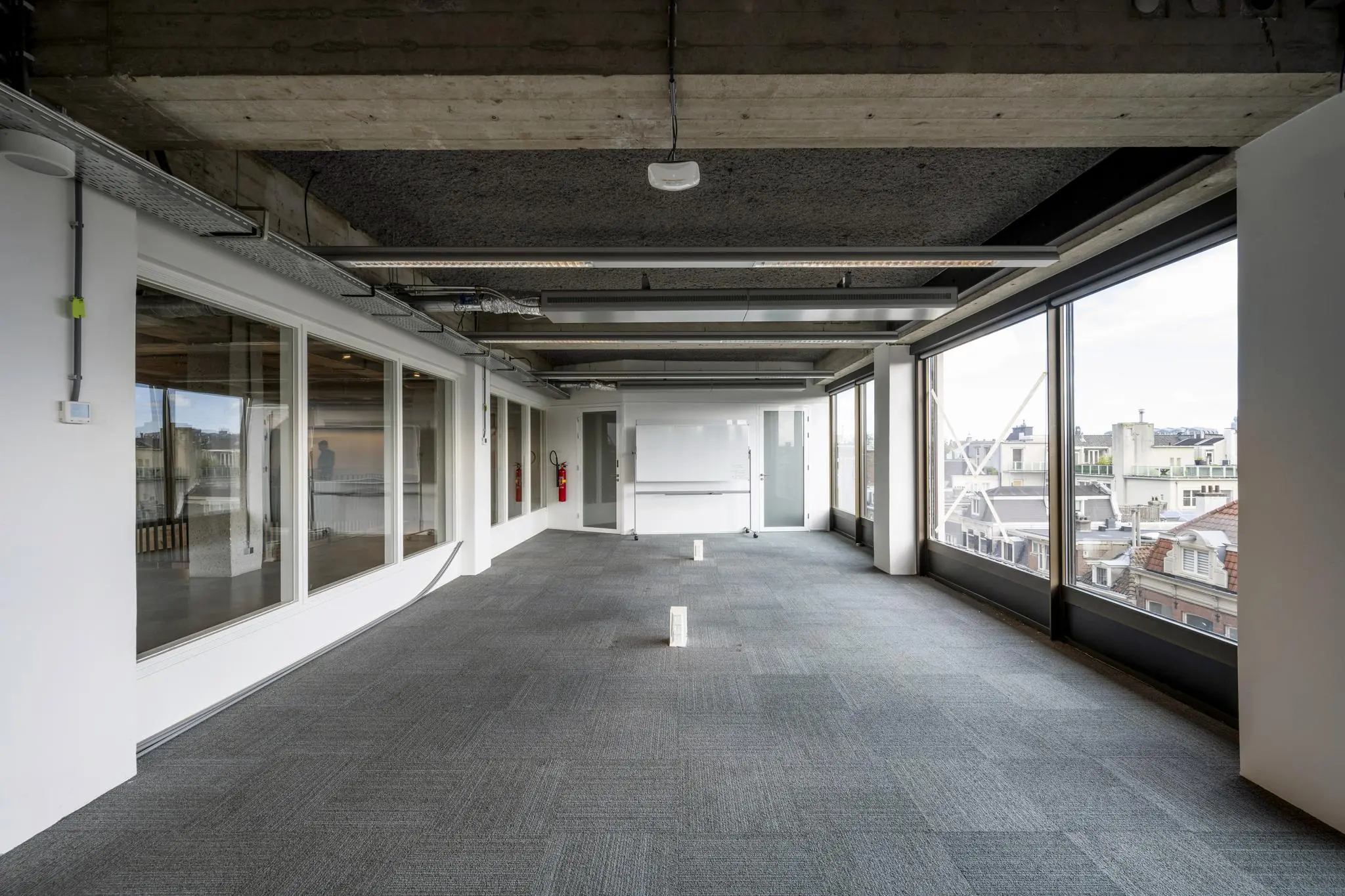 Licht en modern kantoorpand aan de Vijzelstraat met grote ramen en een industrieel plafond.