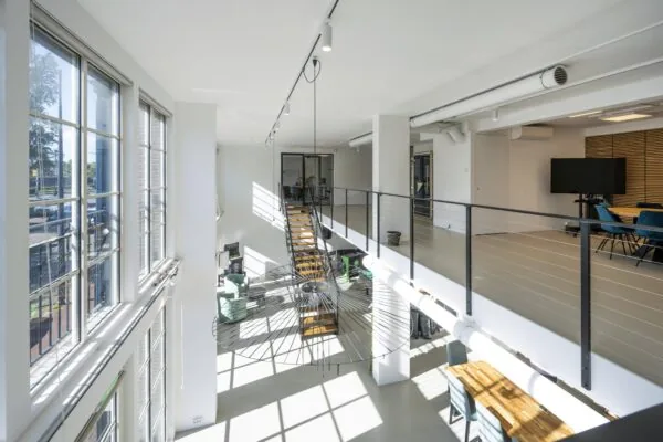 Modern kantoorinterieur aan de Oostelijke Handelskade met veel daglicht, een open trap en glazen vergaderruimte.