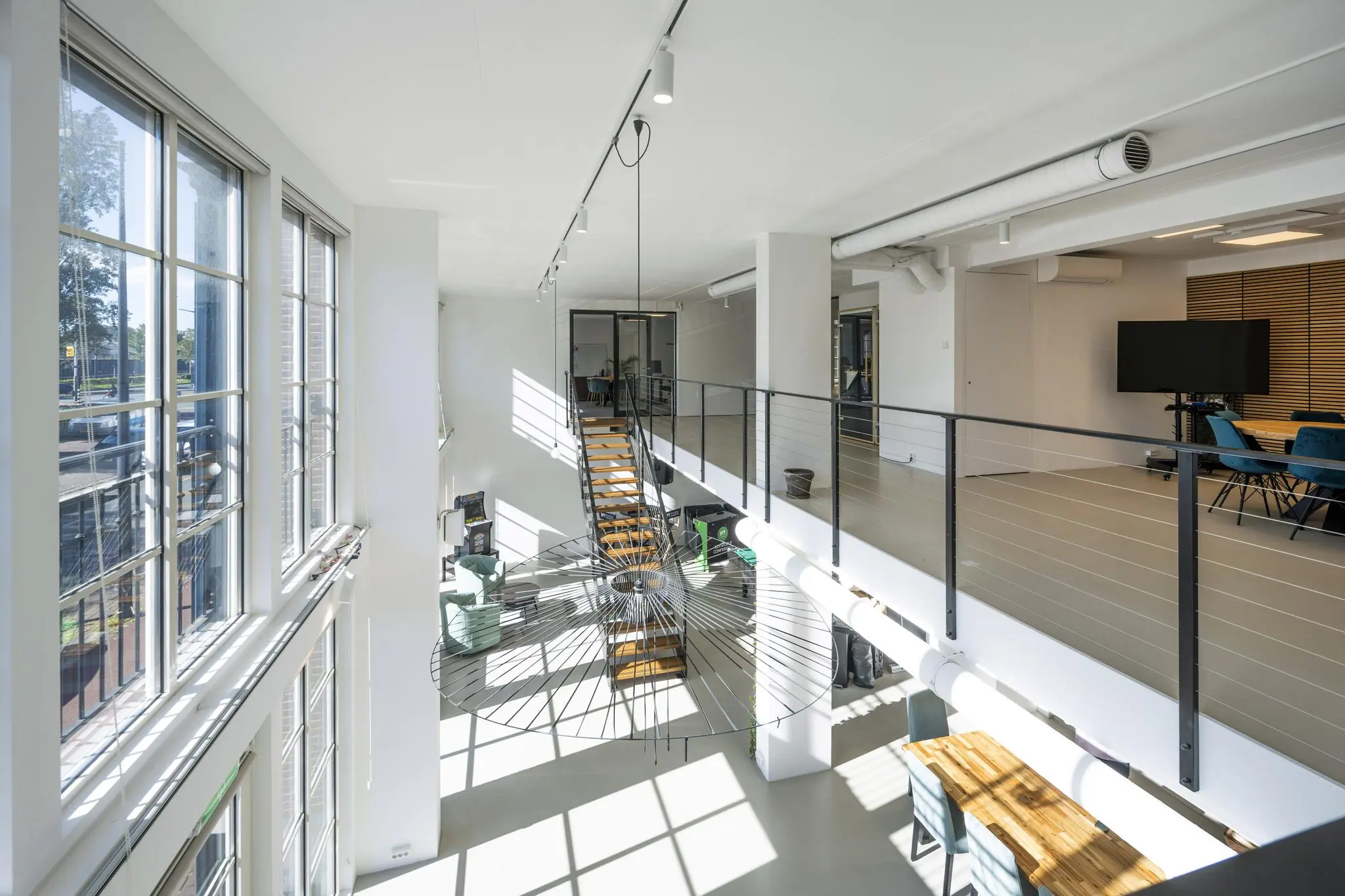 Modern kantoorinterieur aan de Oostelijke Handelskade met veel daglicht, een open trap en glazen vergaderruimte.