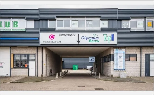 Bedrijfsverzamelgebouw aan de Hoofdweg 240-260 met zicht op doorgang en bedrijfsnaamborden.