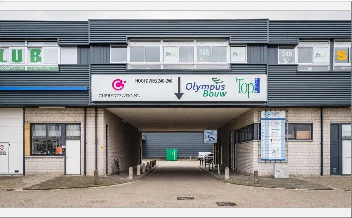 Bedrijfsverzamelgebouw aan de Hoofdweg 240-260 met zicht op doorgang en bedrijfsnaamborden.