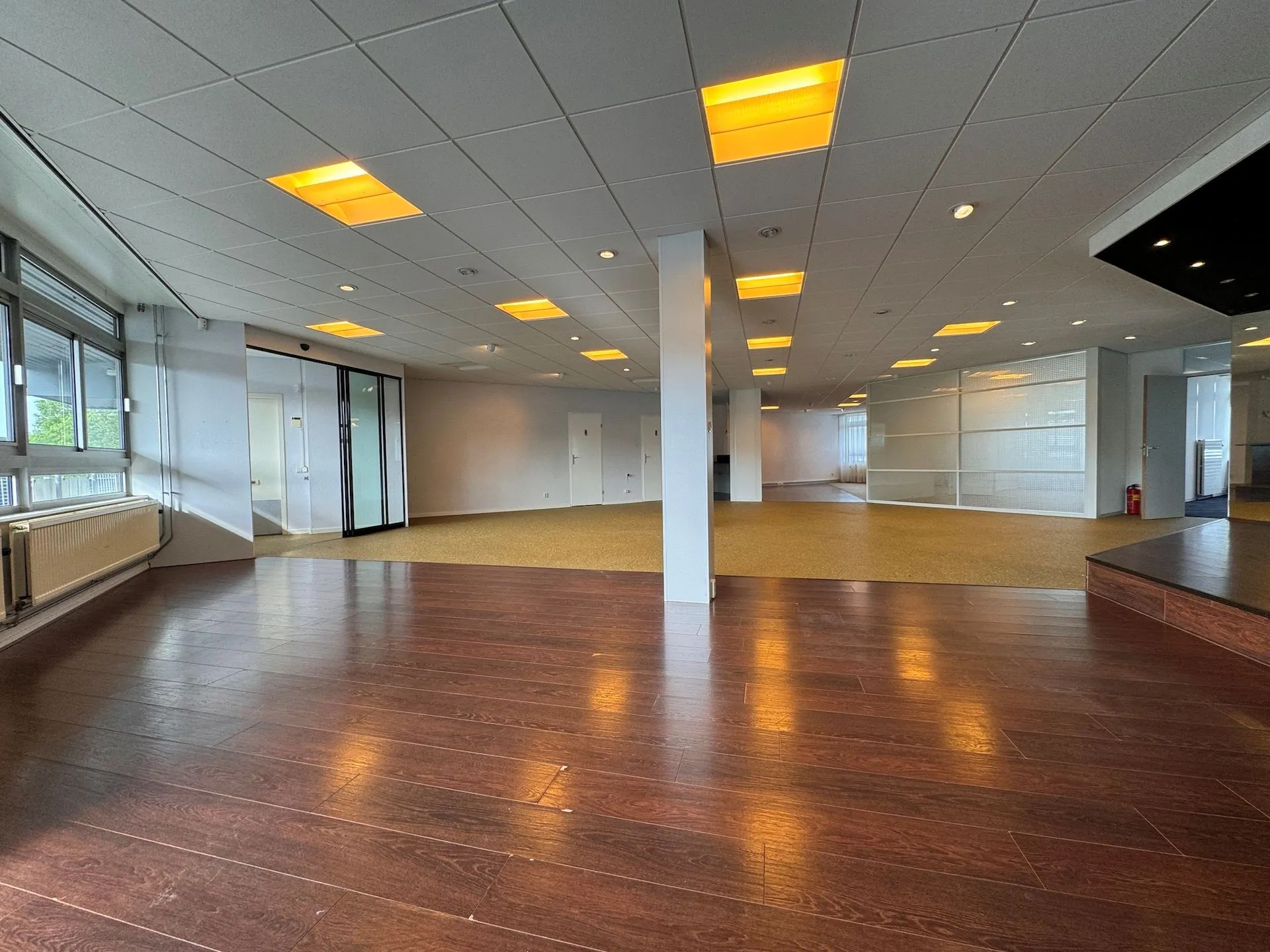 Ruim en modern kantoorpand aan de Hoofdweg met houten en tapijtvloer, systeemplafond en veel glas.
