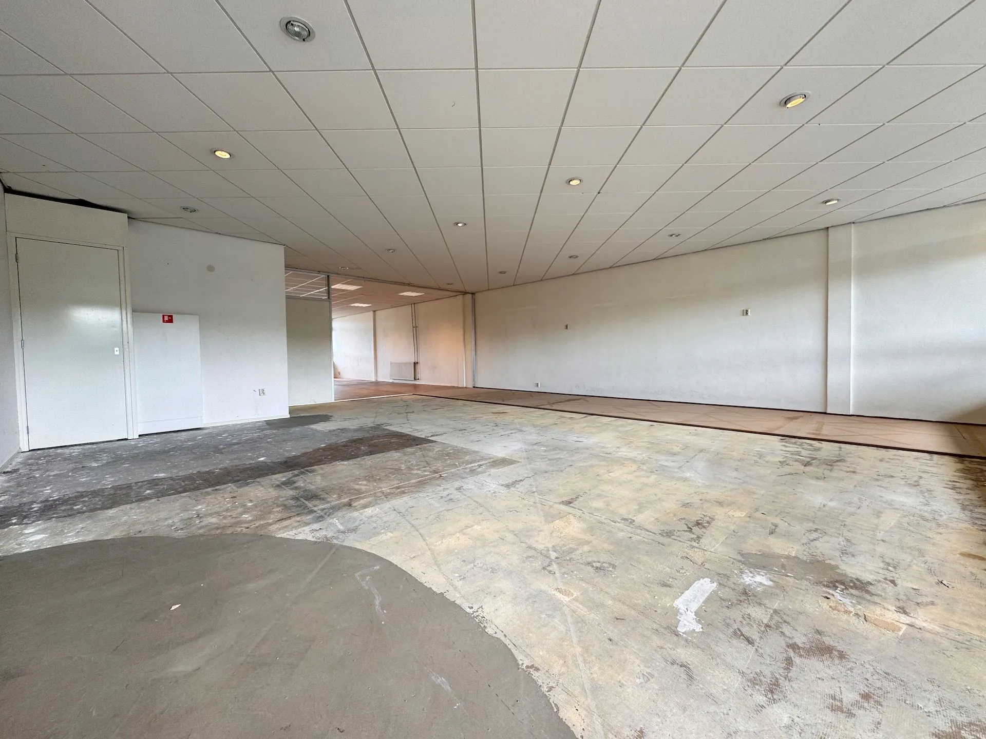 Leegstaand kantoorpand aan de Hoofdweg met deels verwijderde vloerbedekking en systeemplafond.