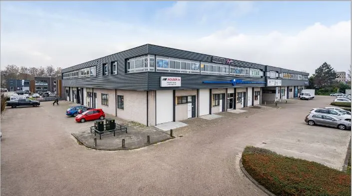 Bedrijfsverzamelgebouw aan de Hoofdweg met meerdere bedrijfsunits en geparkeerde auto's op het terrein.