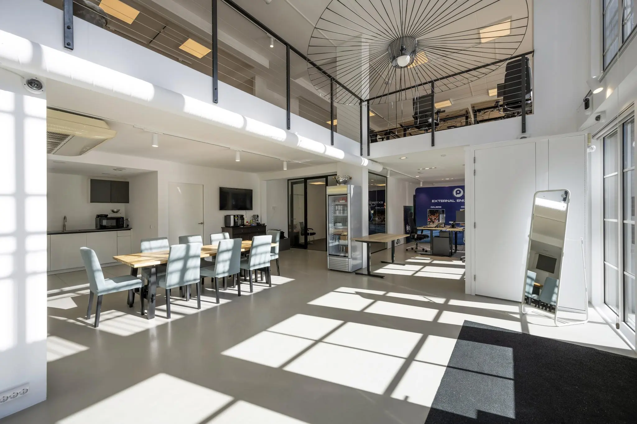 Modern en licht kantoorinterieur aan de Oostelijke Handelskade met vergadertafel, keuken en open bovenverdieping.