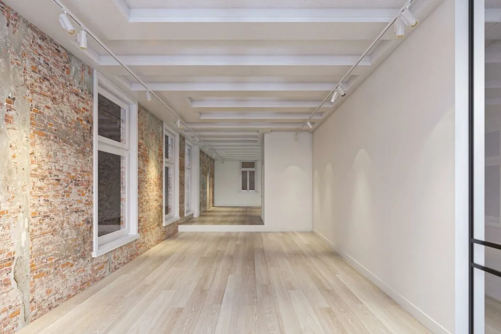 Licht en modern interieur van een ruimte aan het Rokin met houten vloer, bakstenen muur en grote ramen.