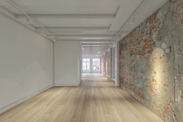 Licht en modern interieur aan het Rokin met houten vloer, bakstenen muur en grote raampartijen aan het einde van de ruimte.