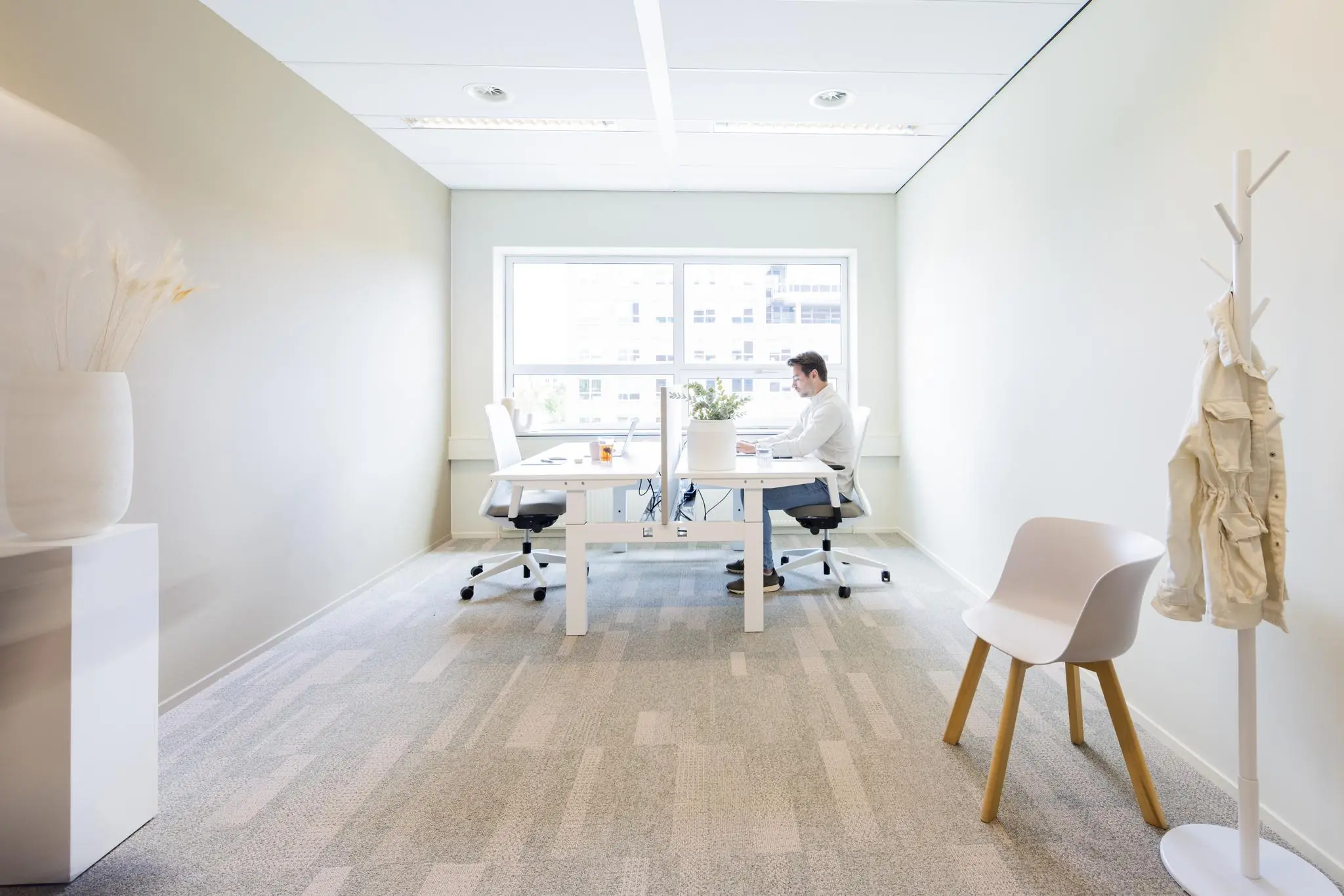 Licht en modern kantoor aan de Rijnzathe met een man werkend aan zijn bureau bij het raam.