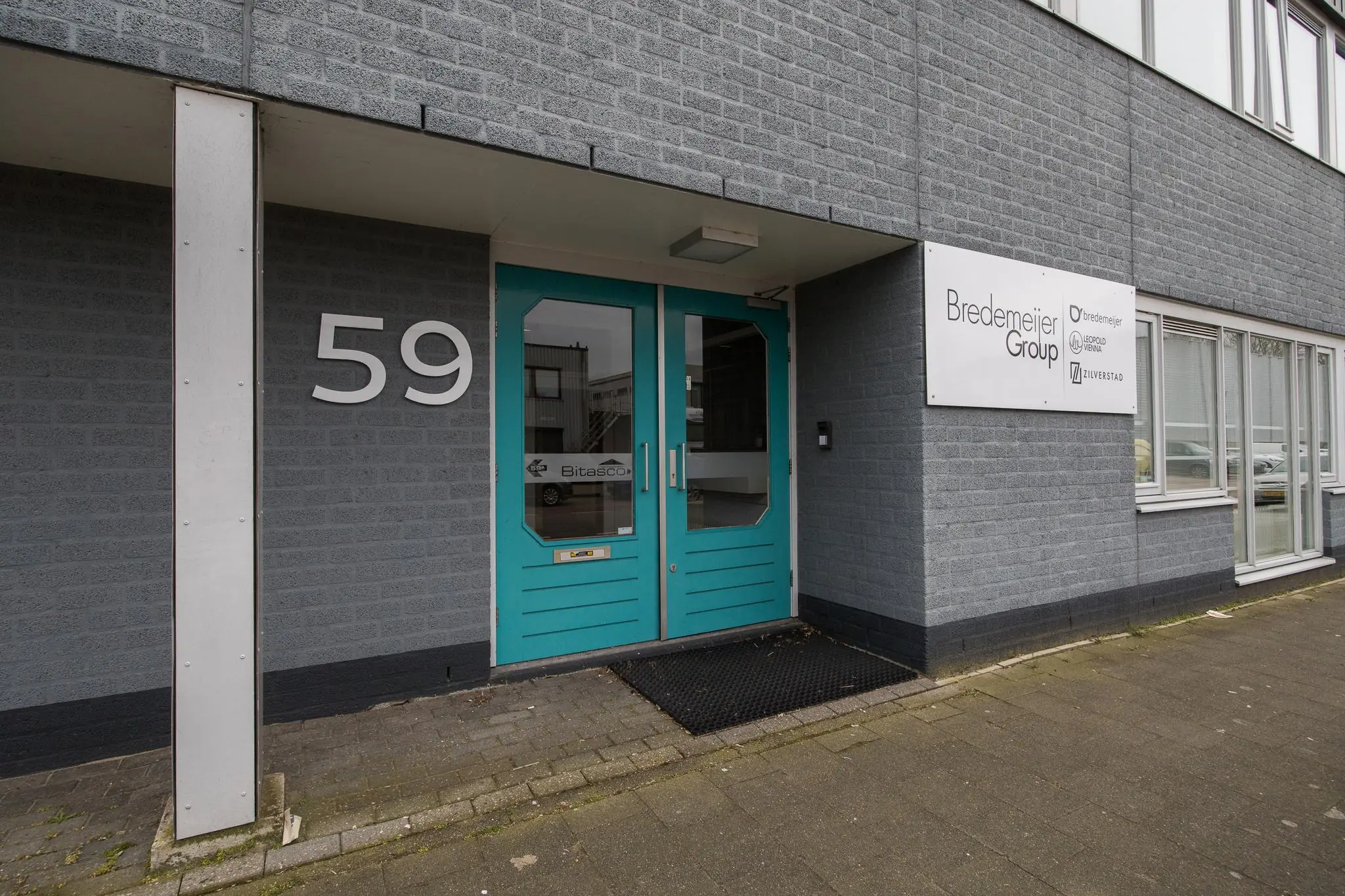 Ingang van het kantoorpand op Savannahweg 59 met het logo van Bredemeijer Group naast de deur.