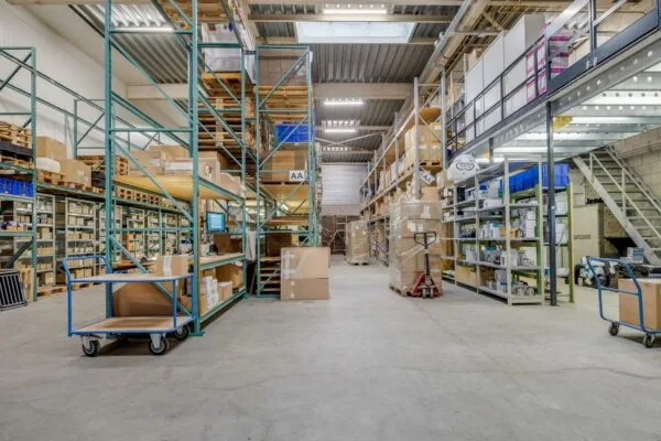 Interieur van een magazijn aan de Savannahweg met stellingen vol dozen, pallets en magazijnkarren.